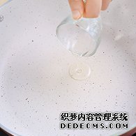 步驟圖:電陶爐開大火，煎炒鍋中倒入少許油。