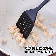 步驟圖:油熱后倒入蝦仁，用鍋鏟翻炒2分鐘至變色，盛出碗中備